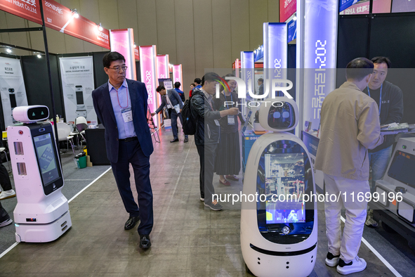 Visitors explore various company booths showcasing robotics and automation technologies at 'RoboWorld 2024' in Goyang, South Korea, on Octob...