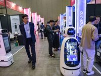 Visitors explore various company booths showcasing robotics and automation technologies at 'RoboWorld 2024' in Goyang, South Korea, on Octob...