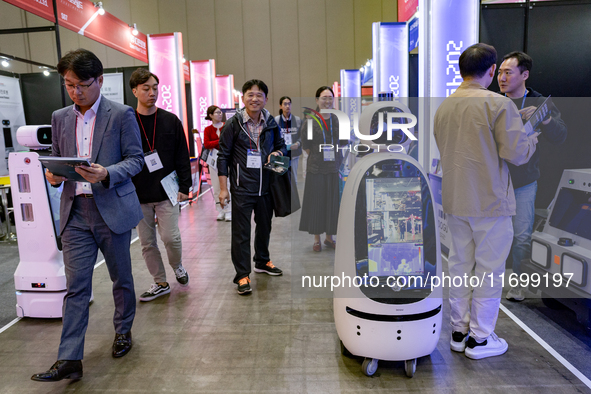 Visitors explore various company booths showcasing robotics and automation technologies at 'RoboWorld 2024' in Goyang, South Korea, on Octob...