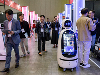 Visitors explore various company booths showcasing robotics and automation technologies at 'RoboWorld 2024' in Goyang, South Korea, on Octob...