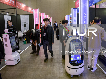 Visitors explore various company booths showcasing robotics and automation technologies at 'RoboWorld 2024,' held at KINTEX in Goyang, South...