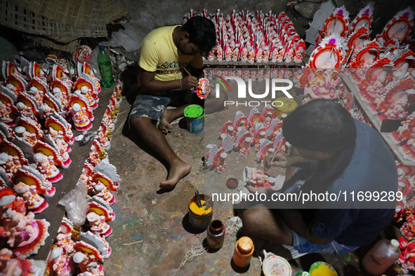 Artists give finishing touches to idols of the Hindu God Ganesh, the God of prosperity, and the Hindu goddess of wealth, Lakshmi, ahead of t...