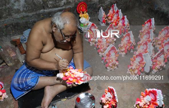 An artist gives finishing touches to an idol of the Hindu Goddess of wealth, Lakshmi, ahead of the Diwali festival, the festival of lights,...