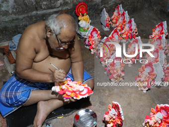 An artist gives finishing touches to an idol of the Hindu Goddess of wealth, Lakshmi, ahead of the Diwali festival, the festival of lights,...