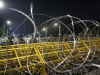 Army personnel stand guard in front of the Bangabhaban, the residence and workplace of President Mohammed Shahabuddin, after protesters dema...