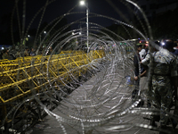 Law enforcers stand guard in front of the Bangabhaban, the residence and workplace of President Mohammed Shahabuddin, after protesters deman...