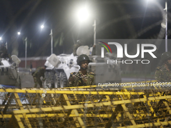 Army personnel stand guard in front of the Bangabhaban, the residence and workplace of President Mohammed Shahabuddin, after protesters dema...