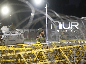 Army personnel stand guard in front of the Bangabhaban, the residence and workplace of President Mohammed Shahabuddin, after protesters dema...