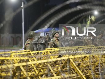 Army personnel stand guard in front of the Bangabhaban, the residence and workplace of President Mohammed Shahabuddin, after protesters dema...