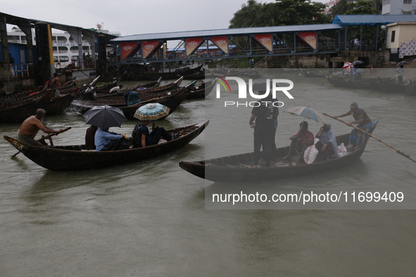 Residents cross over the Buriganga River by boat during the rainfall in Dhaka, Bangladesh, on October 23, 2024. 