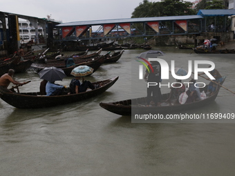 Residents cross over the Buriganga River by boat during the rainfall in Dhaka, Bangladesh, on October 23, 2024. (