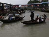 Residents cross over the Buriganga River by boat during the rainfall in Dhaka, Bangladesh, on October 23, 2024. (