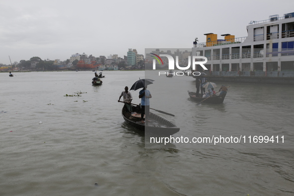 Residents cross over the Buriganga River by boat during the rainfall in Dhaka, Bangladesh, on October 23, 2024. 