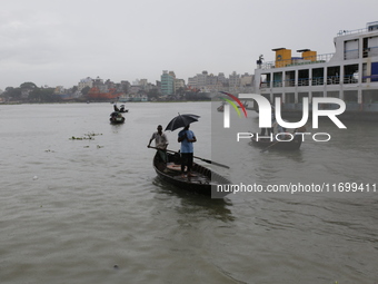 Residents cross over the Buriganga River by boat during the rainfall in Dhaka, Bangladesh, on October 23, 2024. (