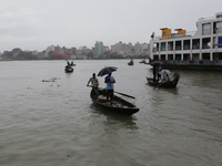 Residents cross over the Buriganga River by boat during the rainfall in Dhaka, Bangladesh, on October 23, 2024. (