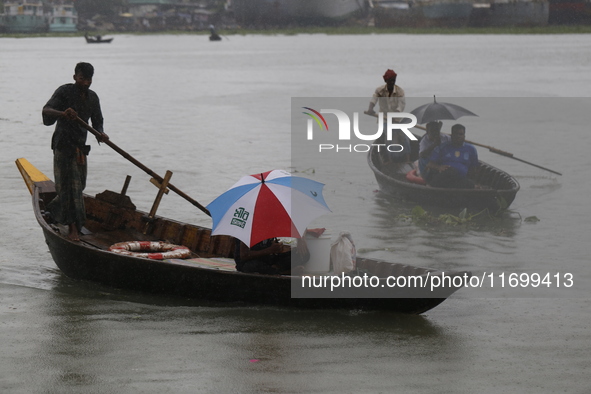 Residents cross over the Buriganga River by boat during the rainfall in Dhaka, Bangladesh, on October 23, 2024. 