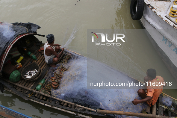 Fishermen catch fish in the Hooghly River near Kolkata, India, on October 23, 2024. 