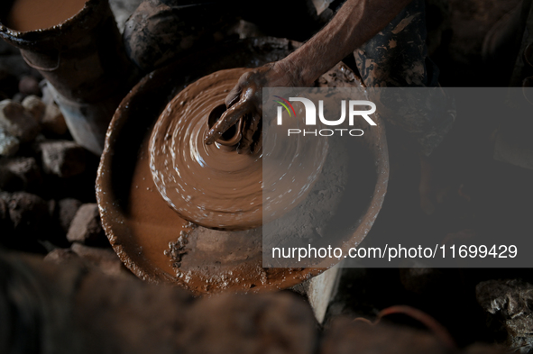 An Indian potter prepares a diya (earthen lamp) at Kumbharwada potter's colony of Dharavi slum in preparation for Diwali (Hindu festival of...