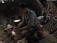 An Indian potter prepares a diya (earthen lamp) at Kumbharwada potter's colony of Dharavi slum in preparation for Diwali (Hindu festival of...