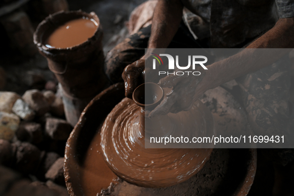 An Indian potter prepares a diya (earthen lamp) at Kumbharwada potter's colony of Dharavi slum in preparation for Diwali (Hindu festival of...