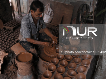 An Indian potter prepares a diya (earthen lamp) at Kumbharwada potter's colony of Dharavi slum in preparation for Diwali (Hindu festival of...