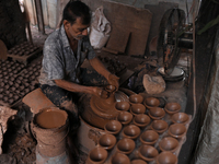 An Indian potter prepares a diya (earthen lamp) at Kumbharwada potter's colony of Dharavi slum in preparation for Diwali (Hindu festival of...