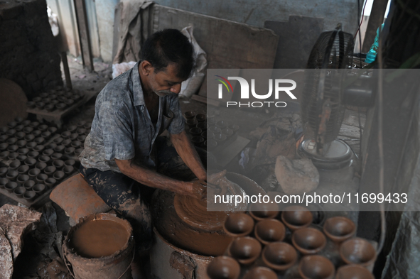 An Indian potter prepares a diya (earthen lamp) at Kumbharwada potter's colony of Dharavi slum in preparation for Diwali (Hindu festival of...