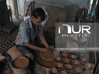 An Indian potter prepares a diya (earthen lamp) at Kumbharwada potter's colony of Dharavi slum in preparation for Diwali (Hindu festival of...