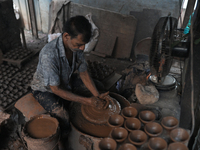 An Indian potter prepares a diya (earthen lamp) at Kumbharwada potter's colony of Dharavi slum in preparation for Diwali (Hindu festival of...