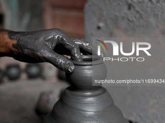 An Indian potter prepares an earthen pot to perform Laxmi Pooja at Kumbharwada potter's colony of Dharavi slum in preparation for Diwali, th...