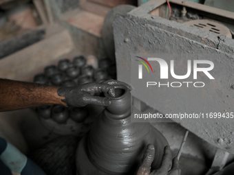 An Indian potter prepares an earthen pot to perform Laxmi Pooja at Kumbharwada potter's colony of Dharavi slum in preparation for Diwali, th...