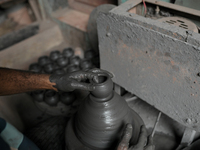 An Indian potter prepares an earthen pot to perform Laxmi Pooja at Kumbharwada potter's colony of Dharavi slum in preparation for Diwali, th...