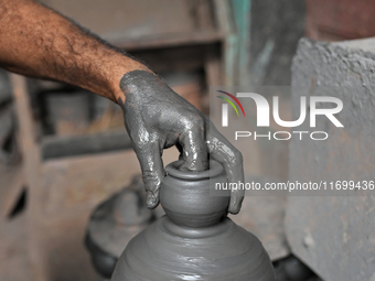 An Indian potter prepares an earthen pot to perform Laxmi Pooja at Kumbharwada potter's colony of Dharavi slum in preparation for Diwali, th...