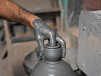 An Indian potter prepares an earthen pot to perform Laxmi Pooja at Kumbharwada potter's colony of Dharavi slum in preparation for Diwali, th...