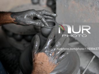 An Indian potter prepares an earthen pot to perform Laxmi Pooja at Kumbharwada potter's colony of Dharavi slum in preparation for Diwali, th...