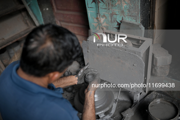 An Indian potter prepares an earthen pot to perform Laxmi Pooja at Kumbharwada potter's colony of Dharavi slum in preparation for Diwali, th...