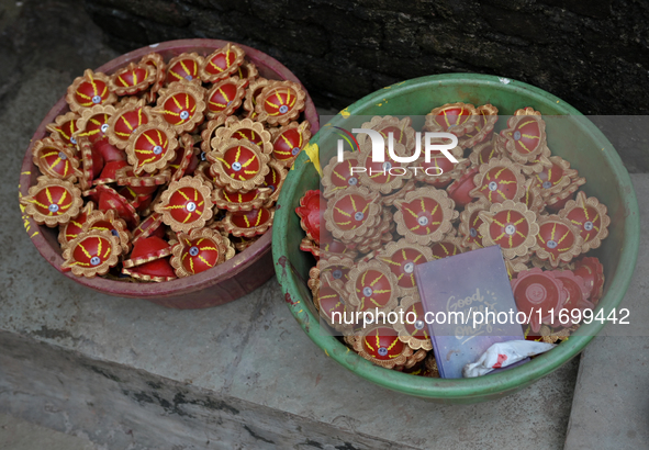 Coloured diyas (earthen lamps) are kept in a storage container at Kumbharwada potter's colony of Dharavi slum in preparation for Diwali (Hin...