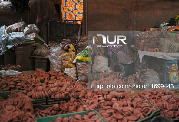 An old woman sells diyas (earthen lamps) to customers at Kumbharwada potter's colony of Dharavi slum in preparation for Diwali (Hindu festiv...