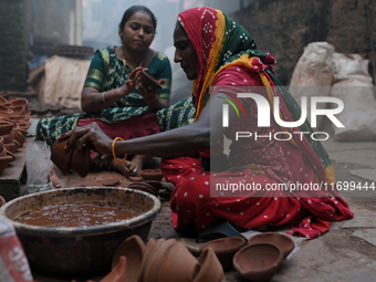 A woman prepares earthen diyas at Kumbharwada potter's colony of Dharavi slum in preparation for Diwali, the Hindu festival of lights, in Mu...