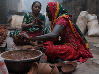 A woman prepares earthen diyas at Kumbharwada potter's colony of Dharavi slum in preparation for Diwali, the Hindu festival of lights, in Mu...