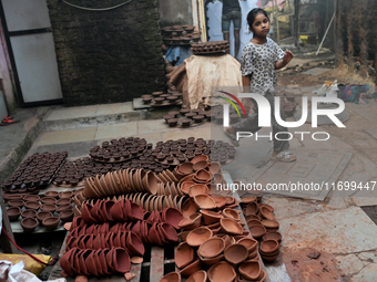 A child walks past diyas (earthen lamps) at Kumbharwada potter's colony of Dharavi slum in preparation for Diwali (Hindu festival of lights)...