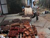 A child walks past diyas (earthen lamps) at Kumbharwada potter's colony of Dharavi slum in preparation for Diwali (Hindu festival of lights)...