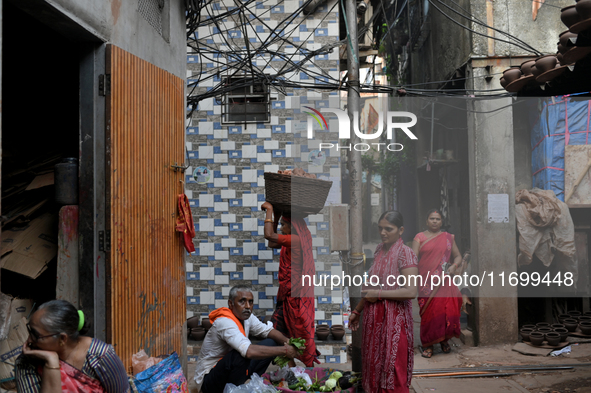 A woman carries earthen diyas on her head at Kumbharwada potter's colony of Dharavi slum in preparation for Diwali, the Hindu festival of li...