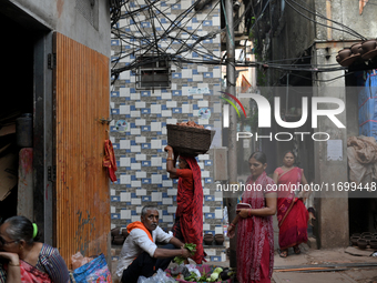 A woman carries earthen diyas on her head at Kumbharwada potter's colony of Dharavi slum in preparation for Diwali, the Hindu festival of li...