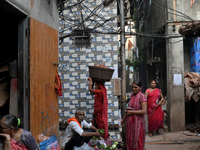 A woman carries earthen diyas on her head at Kumbharwada potter's colony of Dharavi slum in preparation for Diwali, the Hindu festival of li...