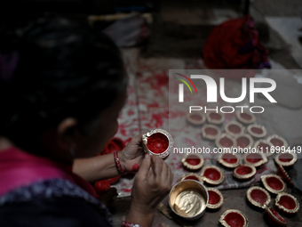 A woman colors diyas (earthen lamps) at Kumbharwada potter's colony of Dharavi slum in preparation for Diwali (Hindu festival of lights) in...