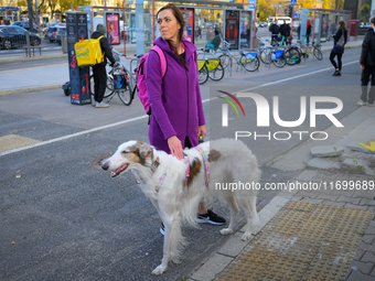 A woman with a large dog is seen outside city hall during a rally against conditions in cat shelters in Warsaw, Poland on 23 October, 2024....