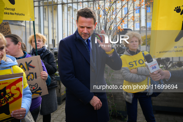 Mayor Rafal Trzaskowski reacts to a loud megafone outside city hall during a demonstration against conditions in cat shelters in Warsaw, Pol...