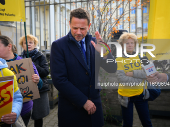 Mayor Rafal Trzaskowski reacts to a loud megafone outside city hall during a demonstration against conditions in cat shelters in Warsaw, Pol...