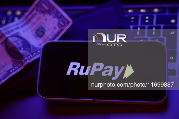 A laptop keyboard, a banknote, a wallet and RuPay logo displayed on a phone screen are seen in this illustration photo taken in Krakow, Pola...